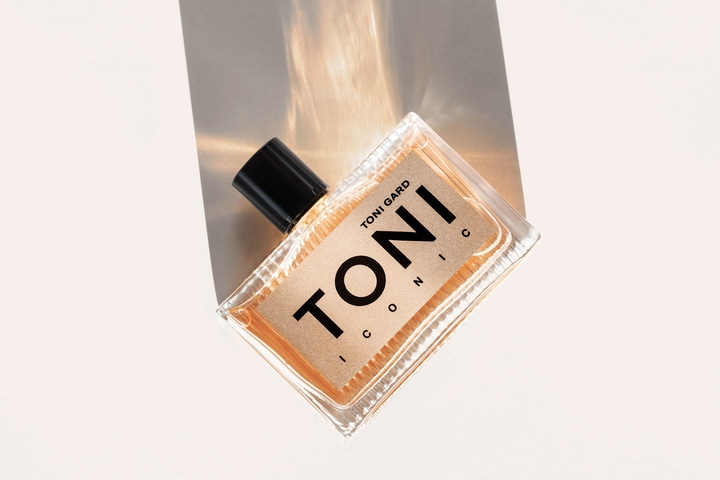 Perfume bottle with the inscription TONI! ICONIC on a light background
