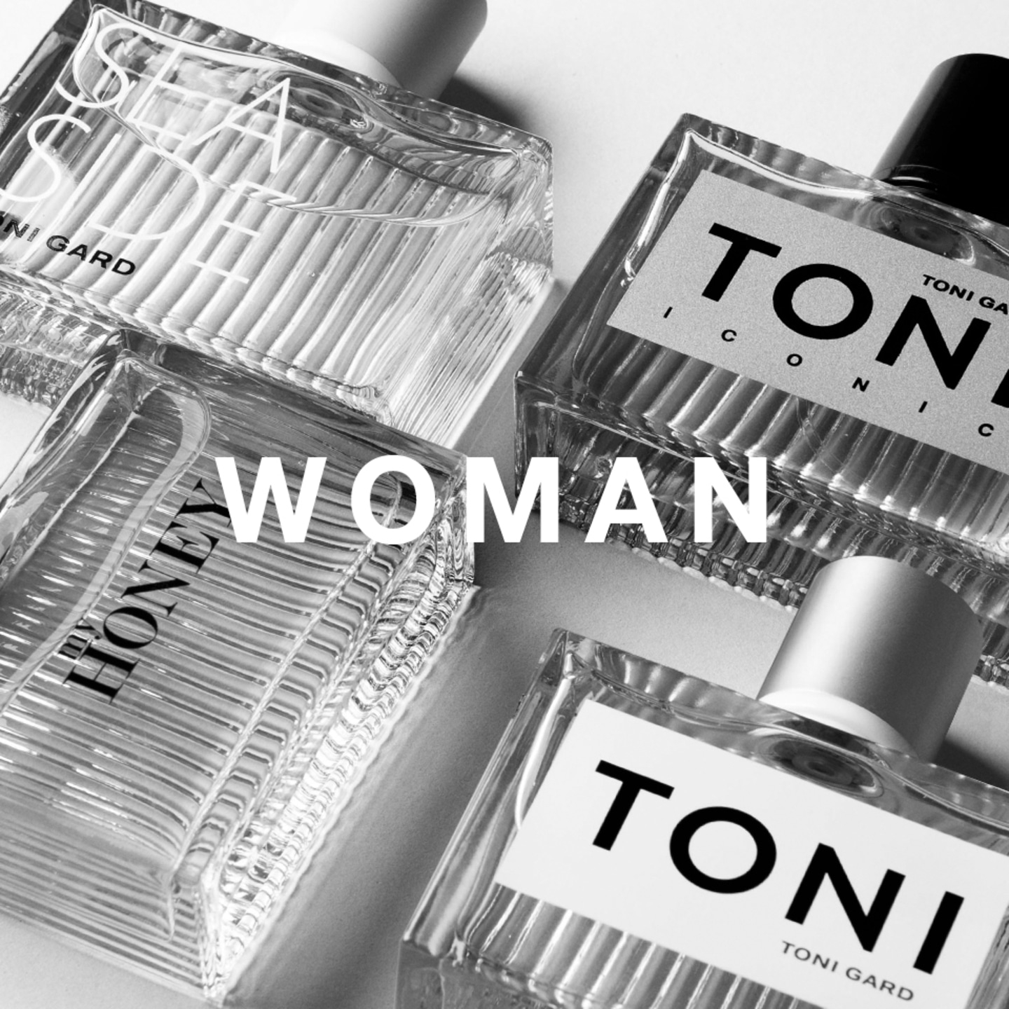 Perfume bottles with the word 'WOMAN' in the middle, in black and white.