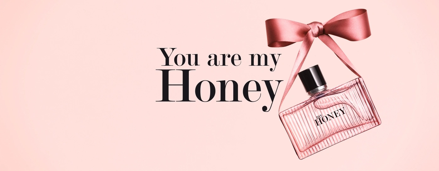 Rosa Parfümflasche mit Schleife und Text 'You are my Honey' auf rosa Hintergrund.
