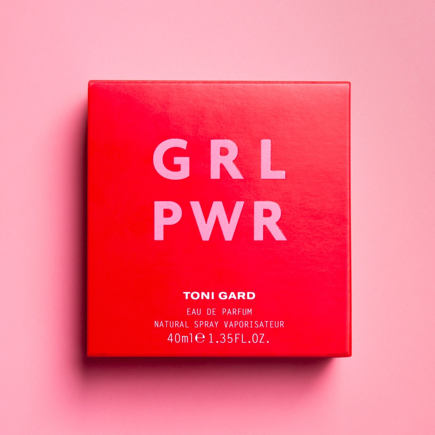 Rote Schachtel mit GRL PWR-Schriftzug und Produktinformationen auf rosa Hintergrund.