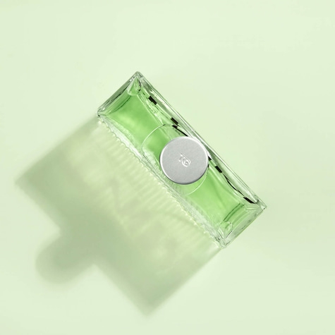 Green perfume bottle on light green background, with shadow, minimalist