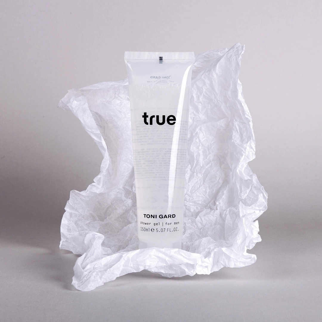 Duschgel-Tube mit der Aufschrift 'true' auf weißem Papier, minimalistisch