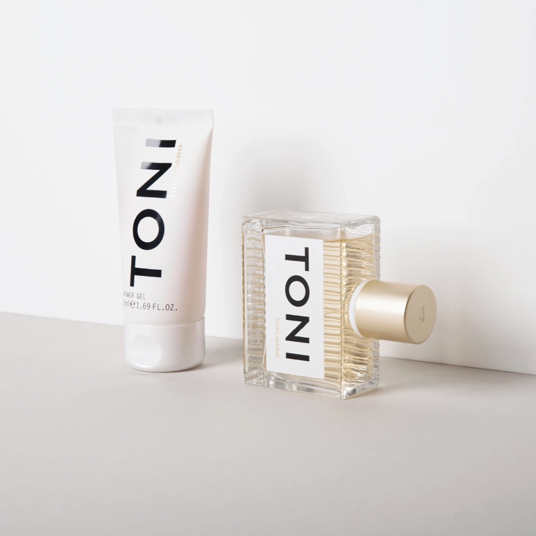 Kosmetikprodukte: Duschgel und Parfümflasche mit dem Schriftzug 'TONI' auf weißem Hintergrund.