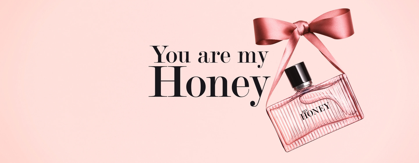 Rosa Parfümflasche mit Schleife und Text 'You are my Honey' auf rosa Hintergrund.